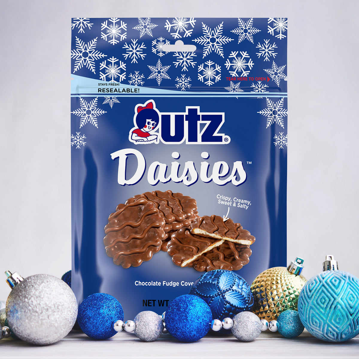 Resealable navy snowflake-print pouch of Utz Daisies, chocolate fudge covered snacks